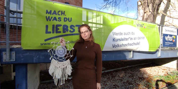 Hannah Wulschner vor einem Banner der vhs Jena