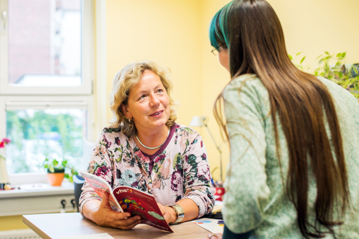 Kundin ist zu Anmeldung in der Volkshochschule Jena an dem Kassen-Tresen